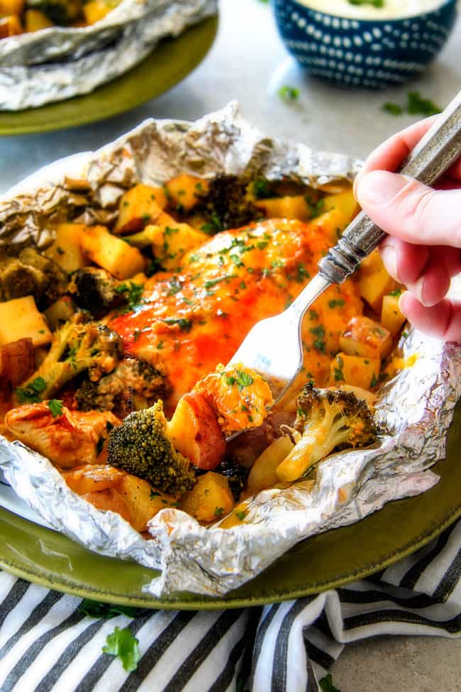 EASY Baked or Grilled Cheesy Buffalo Chicken Foil Packets bursting with juicy chicken and tender, flavorful veggies all smothered in cheddar and dipped in Ranch Crema! ย these are SO addictingly delicious!!! ย ย