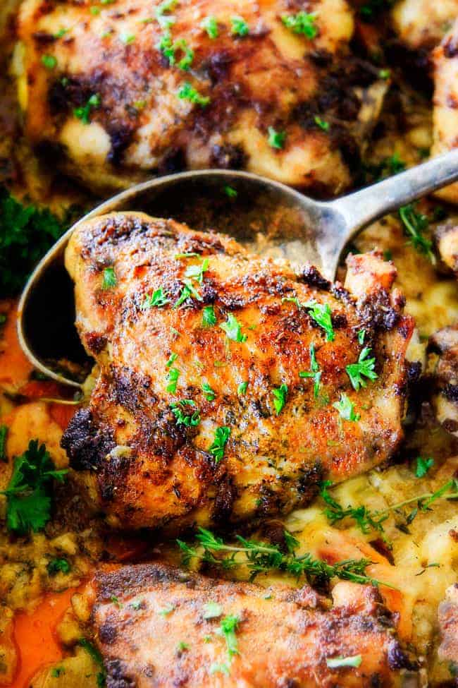 A Baked Garlic Herb Chicken served with a spoon.
