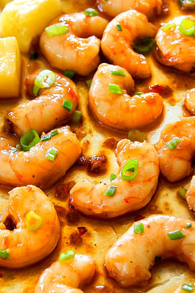 I am in love with this Sheet Pan Teriyaki Shrimp, Pineapple and Snap Peas! ย Its SO easy, healthy, a meal-in-one and the homemade Teriyaki sauce is the best I've ever had (DON'T be tempted to use store bought!)! ย I'm always keeping frozen shrimp on hand so I can make this any time!ย up close of the best teriyaki shrimp glazed in homemade teriyaki sauce