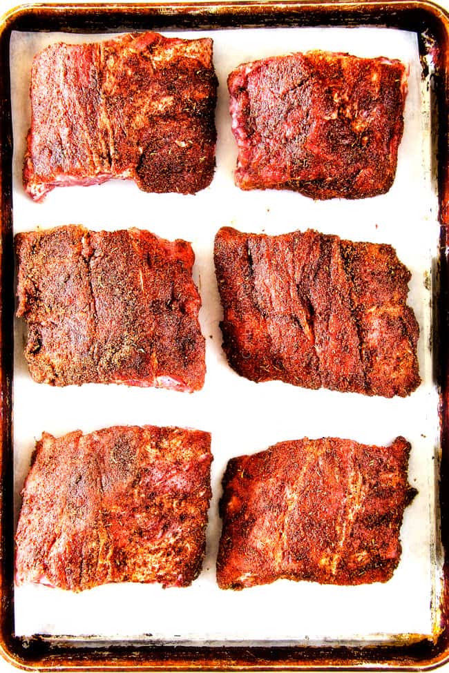 Showing how to make Slow Cooker Honey Buffalo Ribs putting rub on meat.