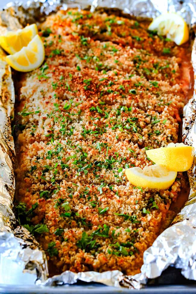 25 MINUTE Baked Lemon Garlic Butter Salmon with Crispy Parmesan Panko & Broccoli!ย This salmon is not only bursting with flavor and sooo juicy and tender but the easiest, most satisfying meal that tastes totally gourmet!ย My parents were blown away by this meal! front view of oven baked salmon garnished with parsley