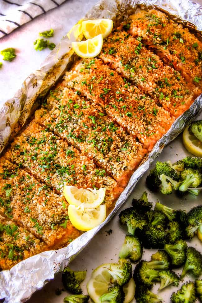 25 MINUTE Baked Lemon Garlic Butter Salmon with Crispy Parmesan Panko & Broccoli!ย This salmon is not only bursting with flavor and sooo juicy and tender but the easiest, most satisfying meal that tastes totally gourmet!ย My parents were blown away by this meal! healthy baked salmon recipe in foil with lemons on the side