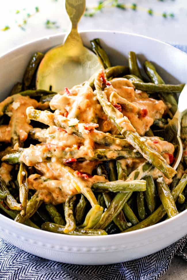 Forget green bean casserole, these wonderfully flavorful, crisp tender Roasted Green Beans with Creamy Gruyere Sauce are AMAZING!!!ย They the best green beans you will ever eat!ย ย They are easy enough for every day but delicious enough for special occasions (like Thanksgiving, Christmas!)!ย up close of the best oven roasted green beans in a white bowl