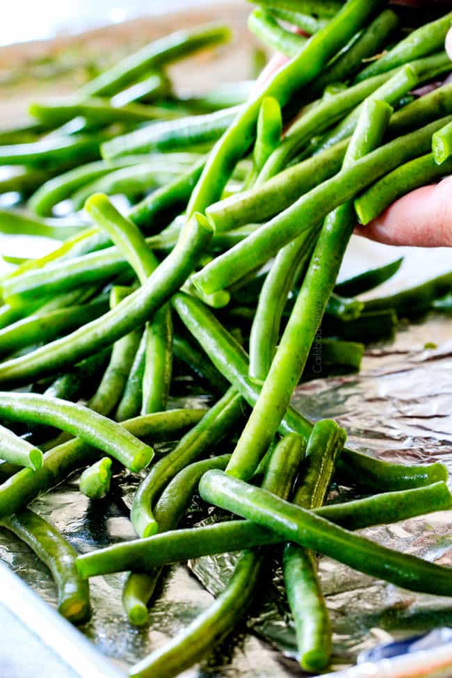 Forget green bean casserole, these wonderfully flavorful, crisp tender Roasted Green Beans with Creamy Gruyere Sauce are AMAZING!!!ย They the best green beans you will ever eat!ย ย They are easy enough for every day but delicious enough for special occasions (like Thanksgiving, Christmas!)!ย ย #greenbeancasserole #thanksgivingrecipe showing how to make roasted green beans by tossing fresh green beans with olive oil, salt and pepper