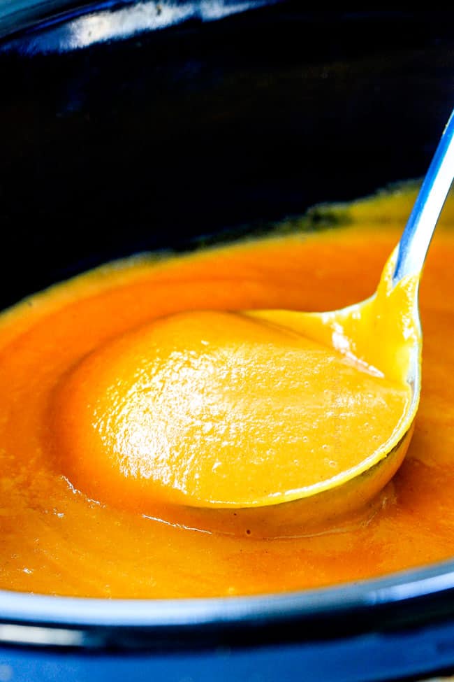 this SUPER creamy Slow Cooker Chipotle Sweet Potato Soup is AMAZING!ย Its loaded with flavor, gluten free, dairy free, crazy healthy and so easy!ย Definitely one of my new favorite soups!ย ย up close of a ladle of full of savory sweet potato soup