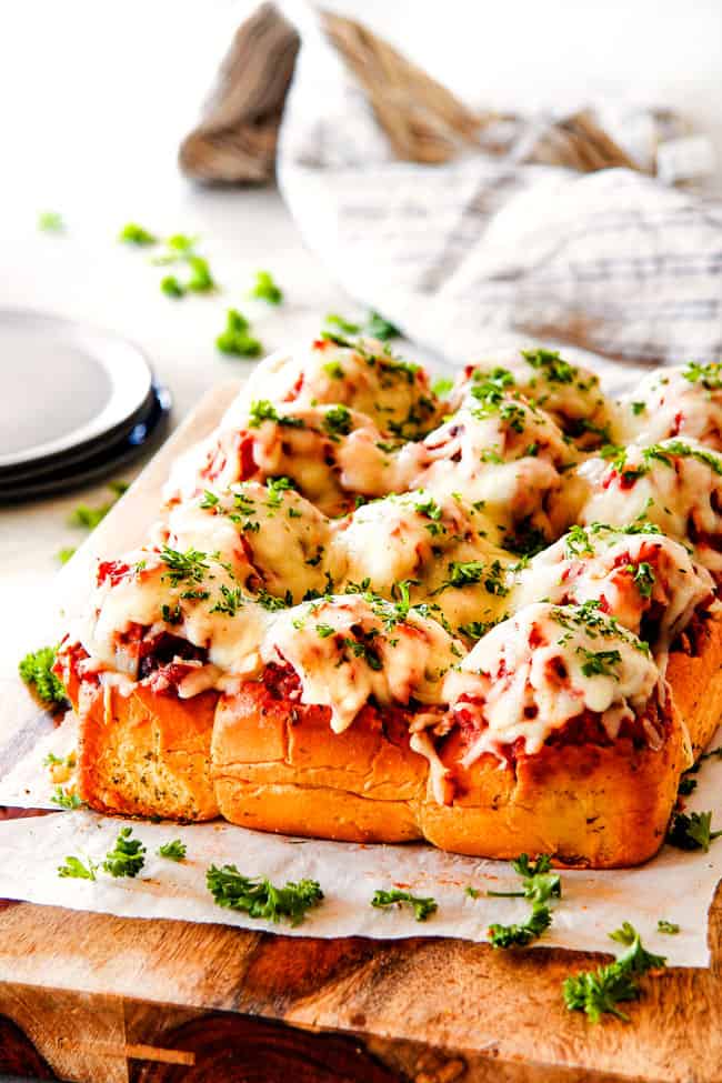 These Cheesy Italian Meatball Sliders are my favorite party food ever and my family loves them for dinner!ย The meatballs are the BEST (so tender and juicy!) and the marinara is amazing and I love how they are individual sliders instead of meatball subs!ย I can't recommend these enough!ย far away view of meatball sliders on Hawaiian buns