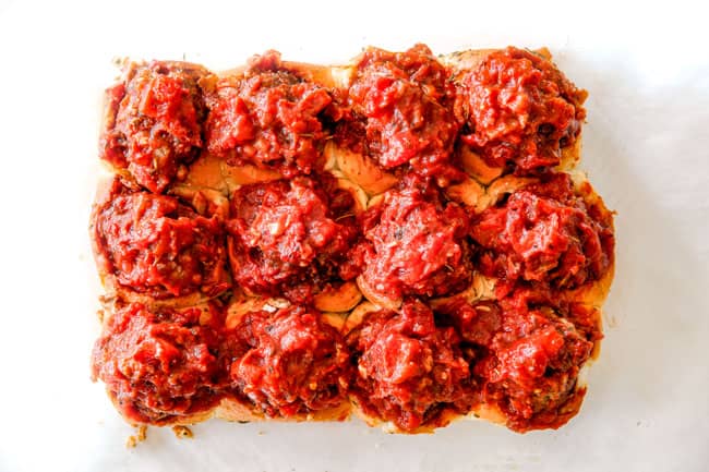 These Cheesy Italian Meatball Sliders are my favorite party food ever and my family loves them for dinner!ย The meatballs are the BEST (so tender and juicy!) and the marinara is amazing and I love how they are individual sliders instead of meatball subs!ย I can't recommend these enough!ย showing how to make meatball sliders by stuffing Italian meatballs into Hawaiian rolls