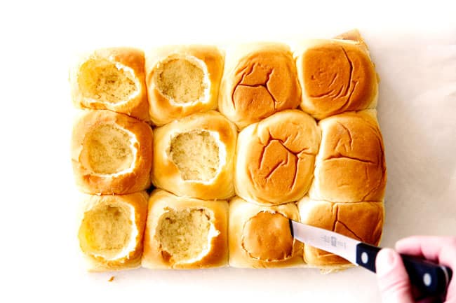 These Cheesy Italian Meatball Sliders are my favorite party food ever and my family loves them for dinner!ย The meatballs are the BEST (so tender and juicy!) and the marinara is amazing and I love how they are individual sliders instead of meatball subs!ย I can't recommend these enough!ย showing how to make meatball sliders by cutting the tops out of Hawaiian rolls