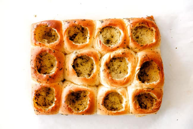 These Cheesy Italian Meatball Sliders are my favorite party food ever and my family loves them for dinner!ย The meatballs are the BEST (so tender and juicy!) and the marinara is amazing and I love how they are individual sliders instead of meatball subs!ย I can't recommend these enough!ย showing how to make meatball sliders by baking Hawaiian rolls until golden