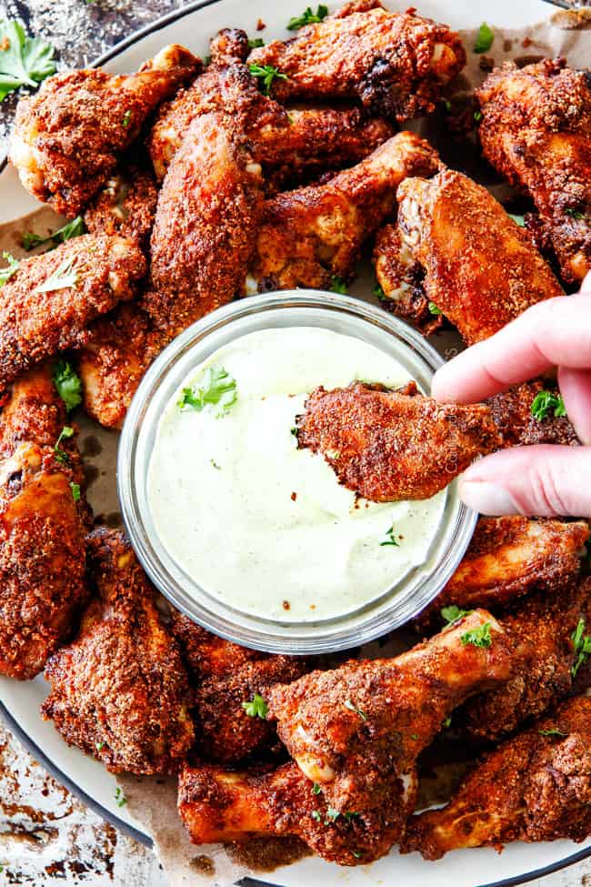 Ancho Baked Chicken Wings dipping in sauce.