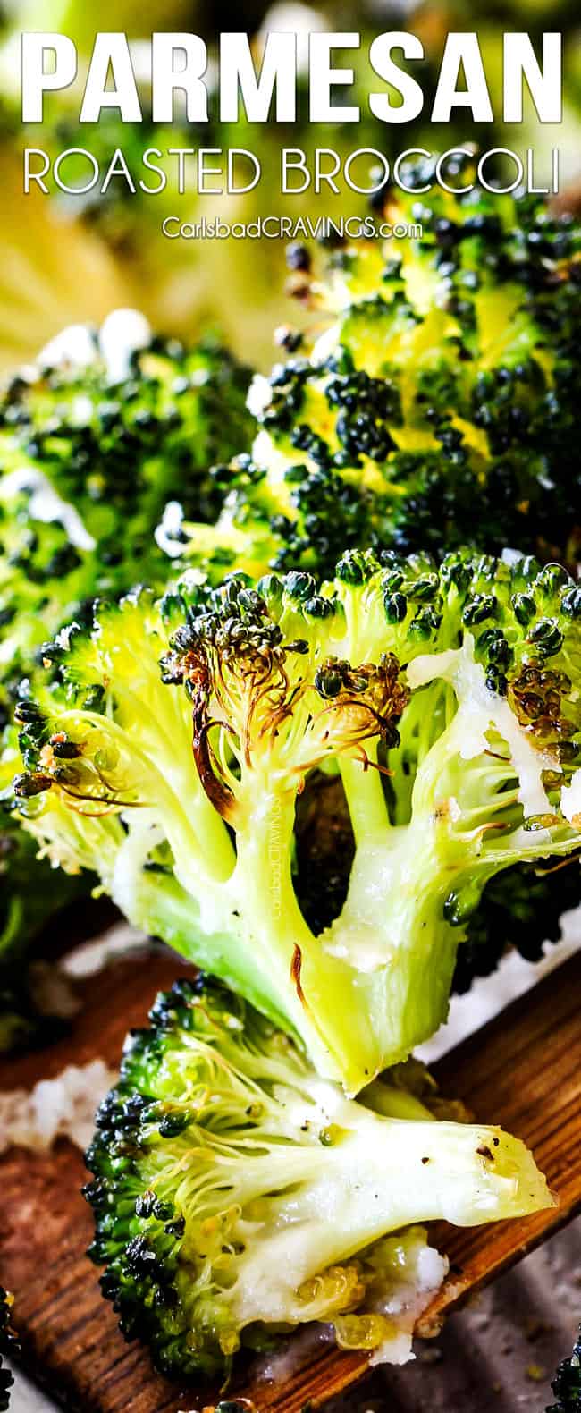 QUICK AND EASY this Parmesan Roasted Broccoli is bursting with flavor, caramelized crispy tops and the quickest side dish to everyย meal all made in ONE PAN!ย AKA Minimal effort, HUGE flavor! up closer of a piece of roasted broccoli with caramelized edges on a wooden spoon