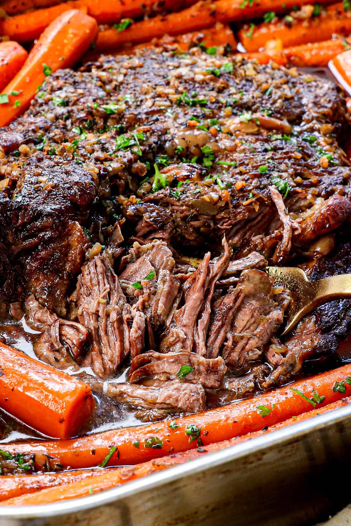 showing how tender the beef roast is shredding it with a fork