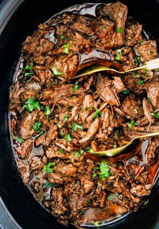 This is the BEST Slow Cooker Barbacoa Beef I have ever tried!ย Super tender, juicy, EASY and bursting with rich, complex flavors!ย Great for large crowds or make ahead meals and makes the best tacos, burritos, nachos, salads, etc!