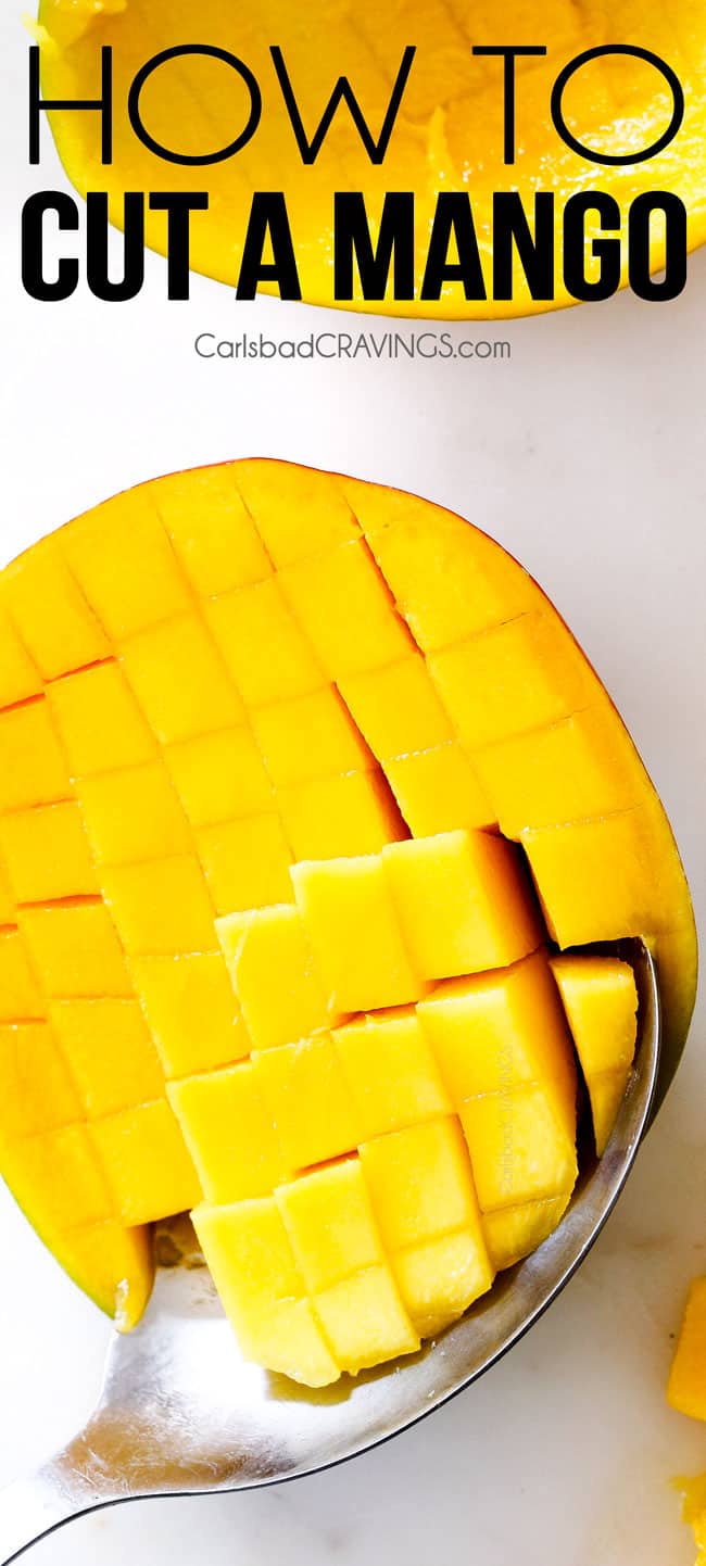 Showing How to Cut a mango with a mango on white cutting board with cubed cuts