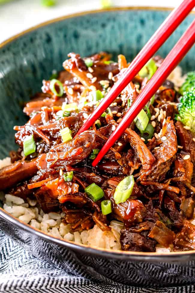 up close of slow cooker Pulled Pork in green bowl with chopsticks
