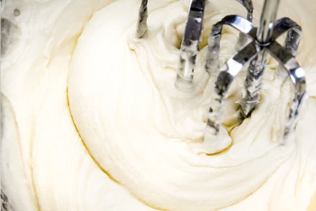 Showing How to make Carrot Cake Cookies by making Cream Cheese Frosting by beating cream cheese, butter and powdered sugar together