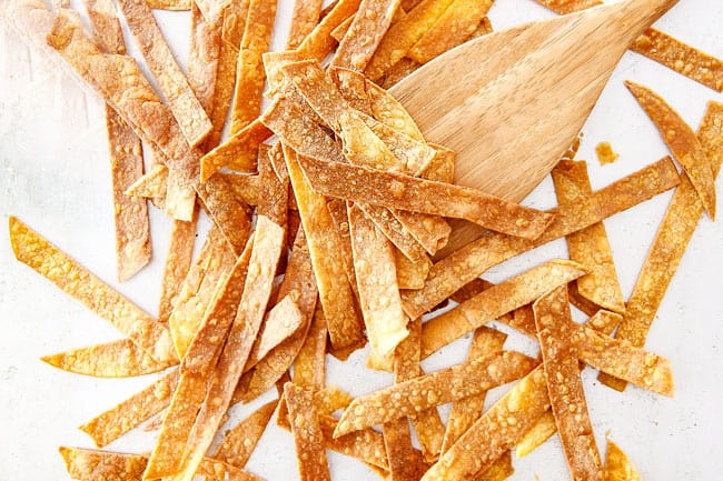 Easy 30-Minute Homemade Chicken Tortilla Soup that tastes better than any restaurant!ย ย It's accidentally healthy, easy to double/triple for a crowd, freezer friendly and tastes like it's been simmering for hours but on your table in 30 Minutes!ย ย Showing How to Make Tortilla Strips for Chicken Tortilla Soup by baking on baking sheet until golden