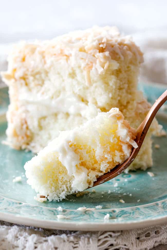 up close shot of easy moist Coconut Cake with a fork of cake on a silver plate