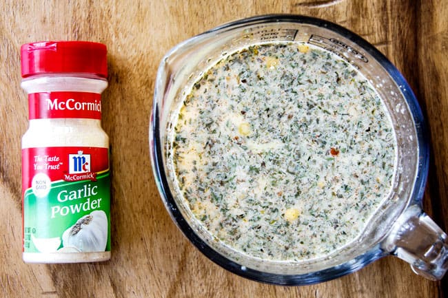 Showing how to make Eggs Benedict Casserole by whisking eggs together with milk and spices in a glass measuring cup