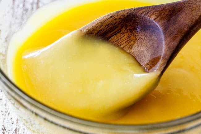 Up close shot of finished lemon curd for Lemon Blueberry Cake in a glass bowl