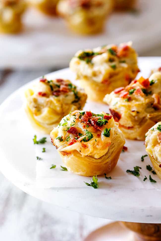 up close shot of 5 Artichoke Dip Bites on a white marble pedestal