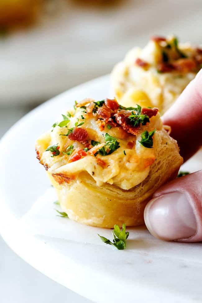 holding Artichoke Dip Bite with two fingers