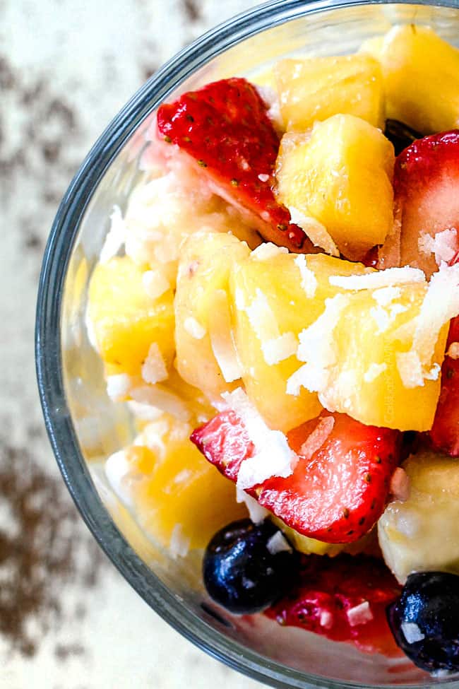 up close view of Pina Colada Fruit Salad in a glass with a spoon