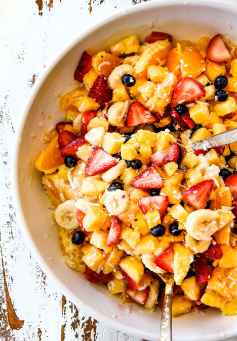 top view of easy Pina Colada Fruit Salad with pineapple, coconut, mandarin oranges, strawberries and blueberries in a white bowl