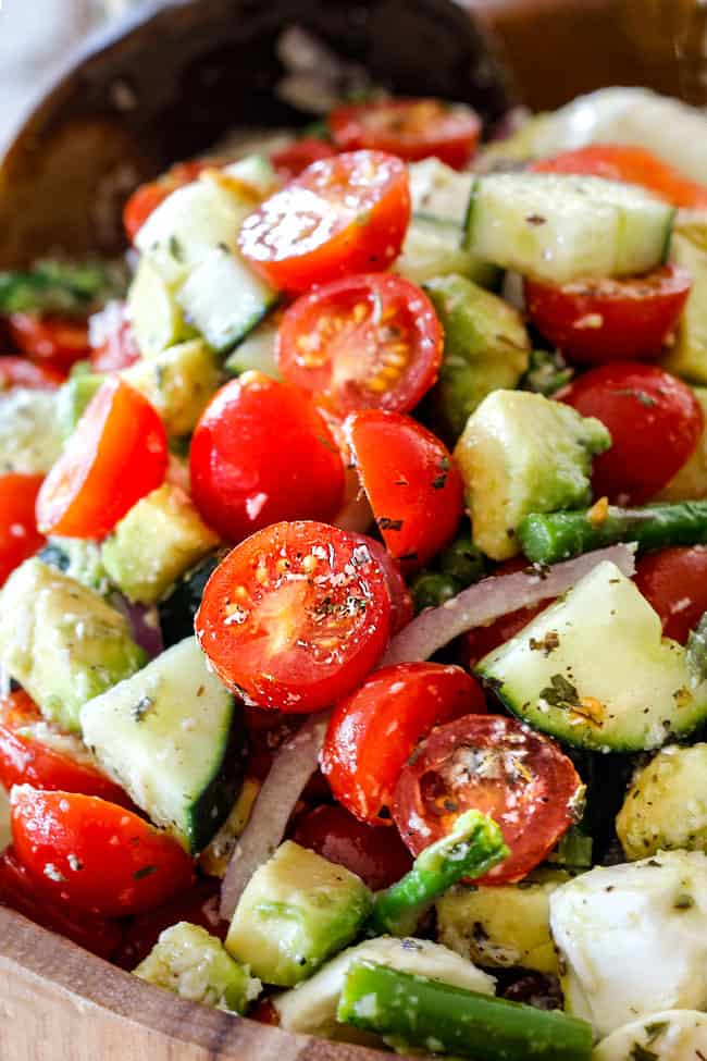 up close of Cucumber Tomato Salad recipe with cherry tomatoes, cucumbers, onion, asparagus and avocado