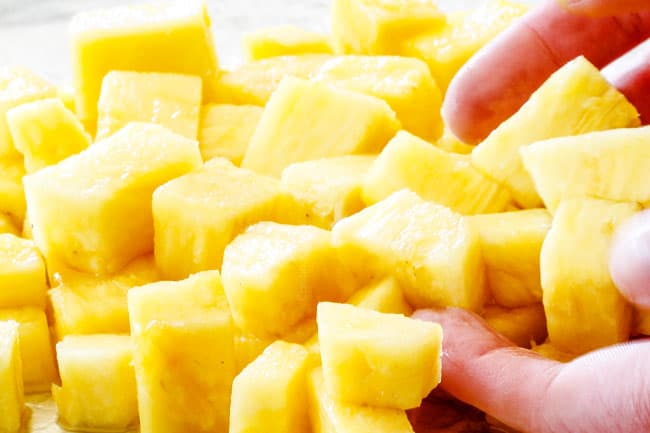 Adding pineapple to baking sheet for sheet pan shrimp fajitas