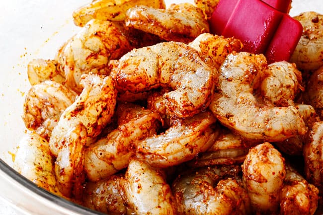 Showing how to make best shrimp fajitas by tossing shrimp with fajita seasoning