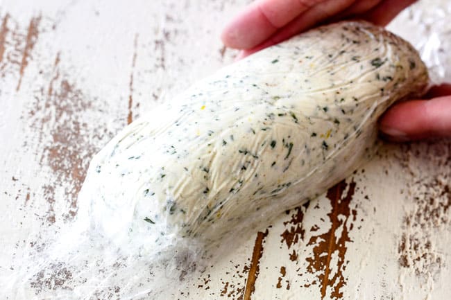showing how to make cheese log by forming cheese log in plastic wrap