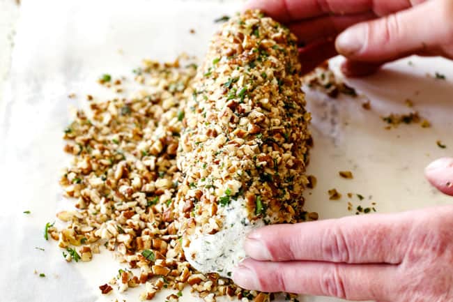 rolling cheese log in pecan mixture showing how to make a cheese log