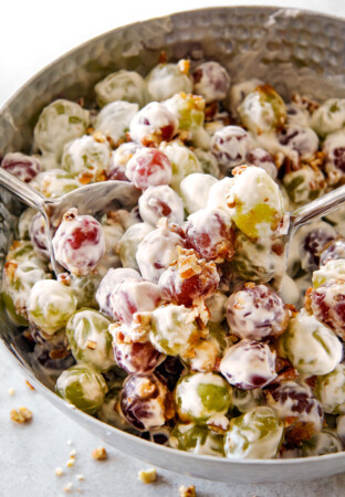 creamy grape salad in a silver bowl with brown sugar and pecans with cream cheese dressing