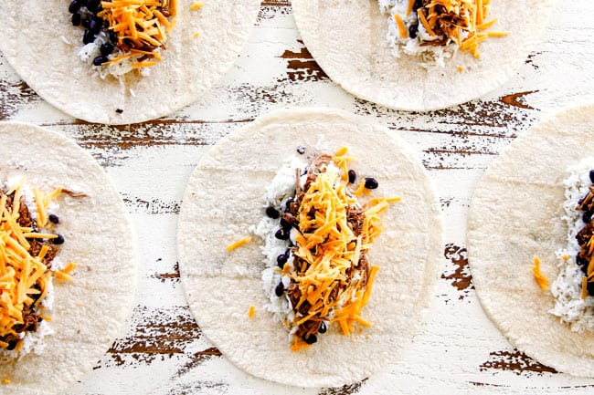 showing how to make wet burritos by layering tortillas with rice, beans, pulled pork and cheese