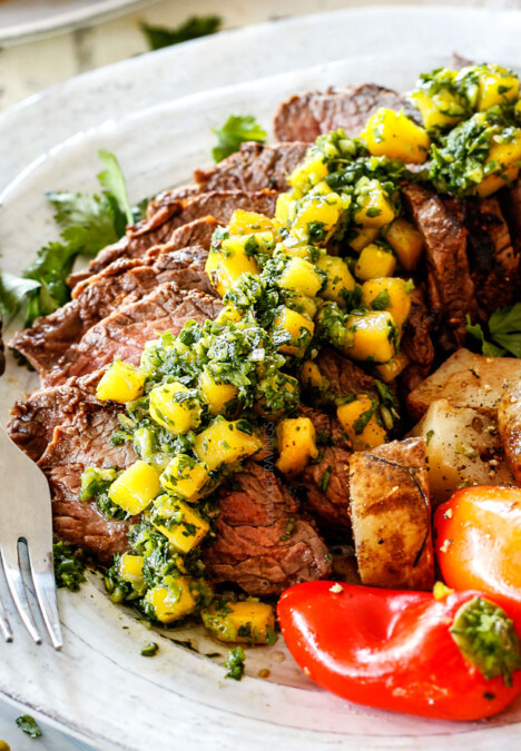 Chimichurri steak sliced on a plate with chimichurri