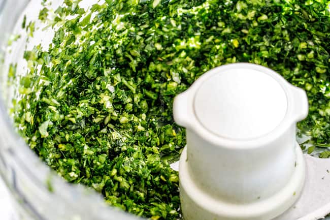 showing how to chop chimichurri for Chimichurri Steak by chopping parsley, cilantro, garlic shallot in food processor