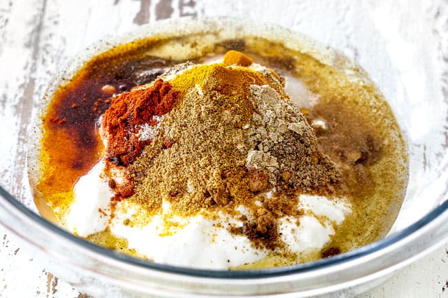 Showing how to make tandoori chicken by adding yogurt marinade ingredients to a glass bowl