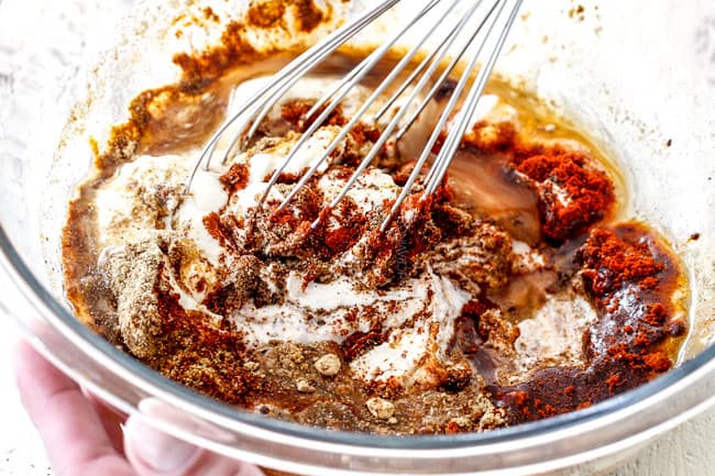 Showing how to make Tandoori Chicken at home by whisking together marinade ingredients of Greek yogurt, lemon juice and spices together in a glass bowl