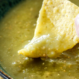 dipping tortilla chip into a bowl of best salsa verde