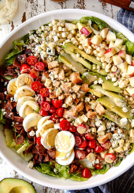 top view of Cobb salad with lettuce, hard boiled eggs, avocados, bacon, tomatoes and blue cheese