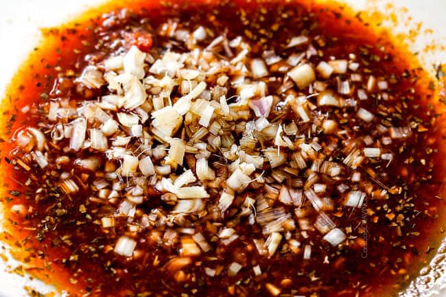 showing how to make lemongrass chicken by whisking together marinade of lemongrass, garlic, ginger, shallots, fish sauce, soy sauce