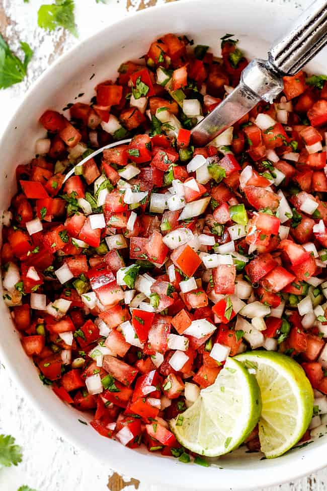 silver bowl in a white bowl of authentic pico de gallo with tomatoes, onions, cilantro, jalapenos, cilantro