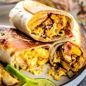 a plate of Mexican Breakfast Burritos sliced in half and stacked on a plate