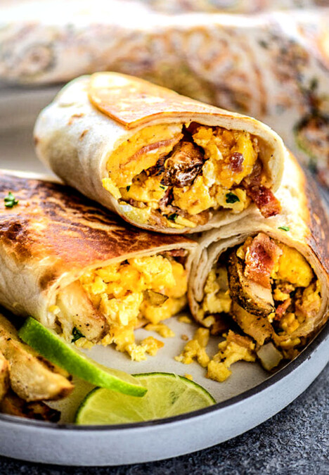 a plate of Mexican Breakfast Burritos sliced in half and stacked on a plate