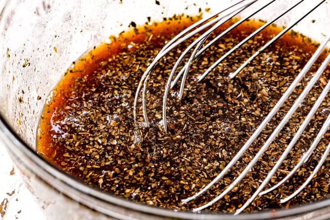 showing how to make sheet pan chicken by whisking together marinade ingredients in a glass bowl