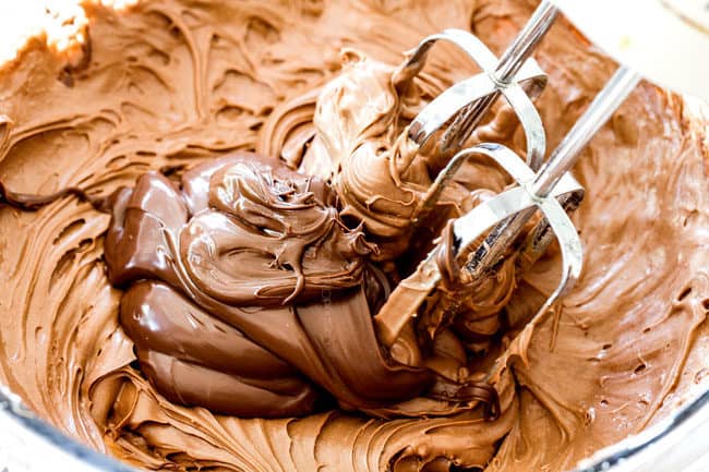 showing how to make a pumpkin roll by whipping the cream cheese frosting ingredients together in a glass bowl