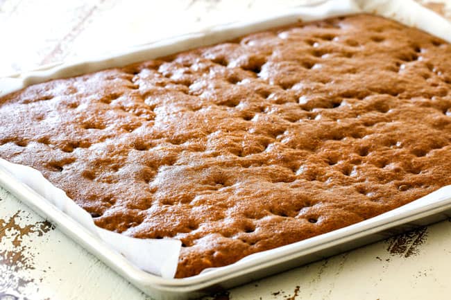 showing how to make pumpkin bars with cream cheese frosting by pulling the baked bars out of the oven