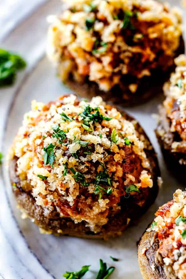 top view of easy sausage stuffed mushrooms on white plate with cream cheese filling