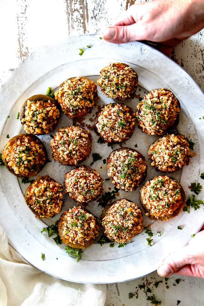 top view of easy sausage stuffed mushrooms on a white serving plate with cream cheese filling